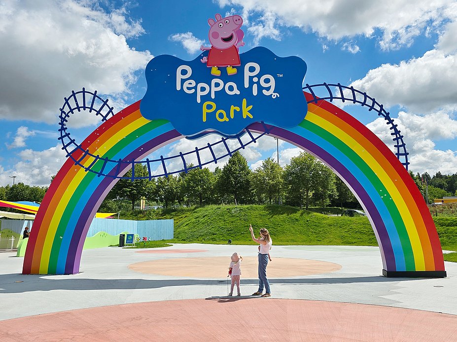 Reiseblogger unter dem Regenbogentor vom Peppa Pig Park